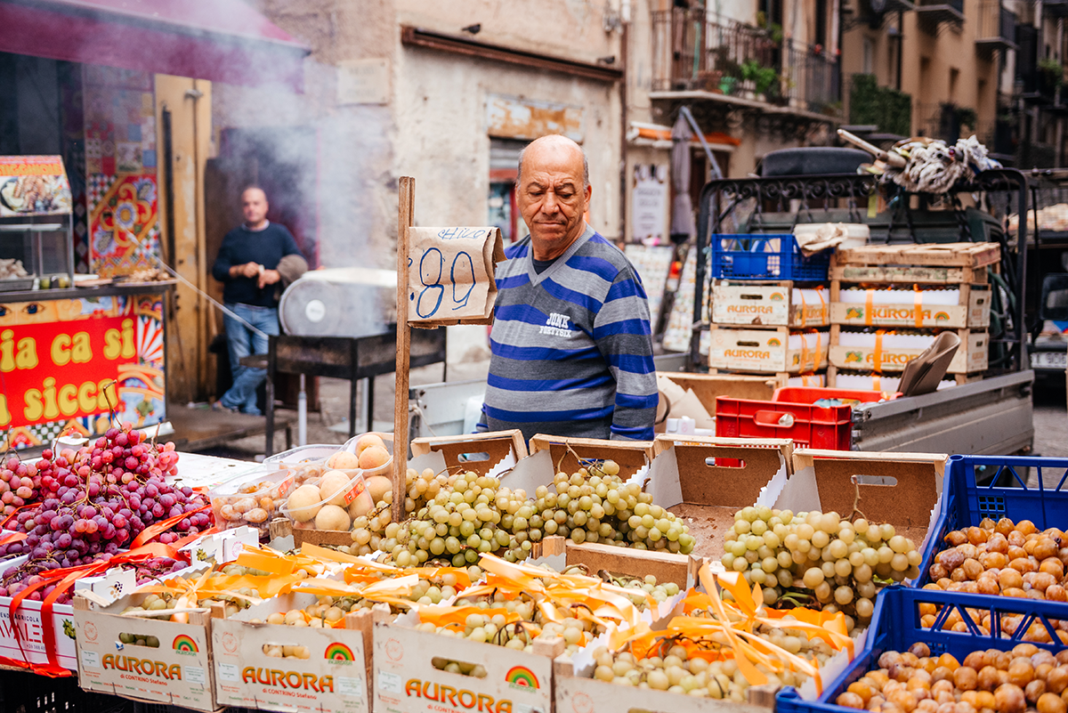 Ballarò Market fruit vendor in Palermo selling grapes for €0.89/kg